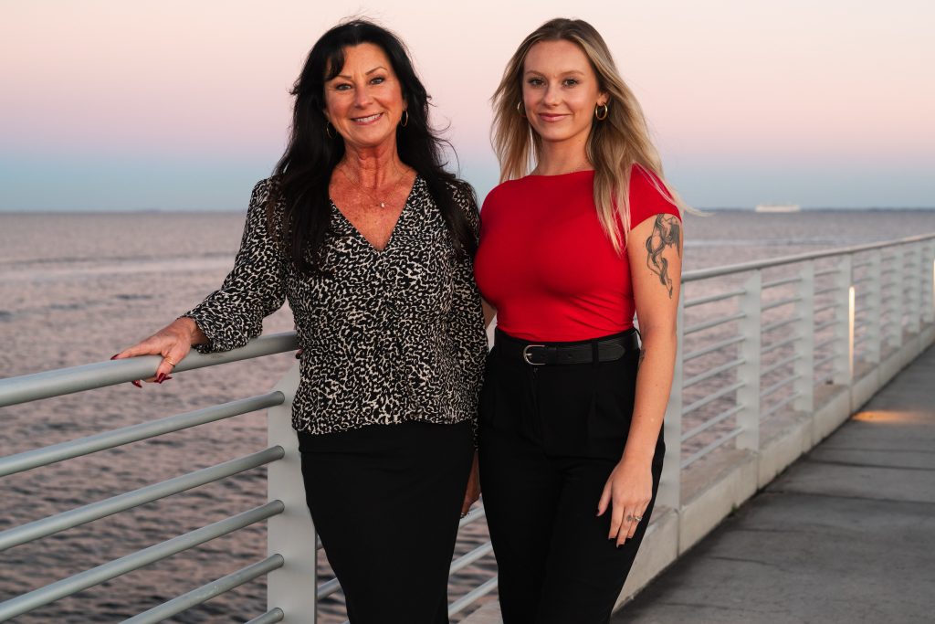 Isabel Allen and Stephanie Meid of Team Sigh on a Tampa Bay pier at sunset